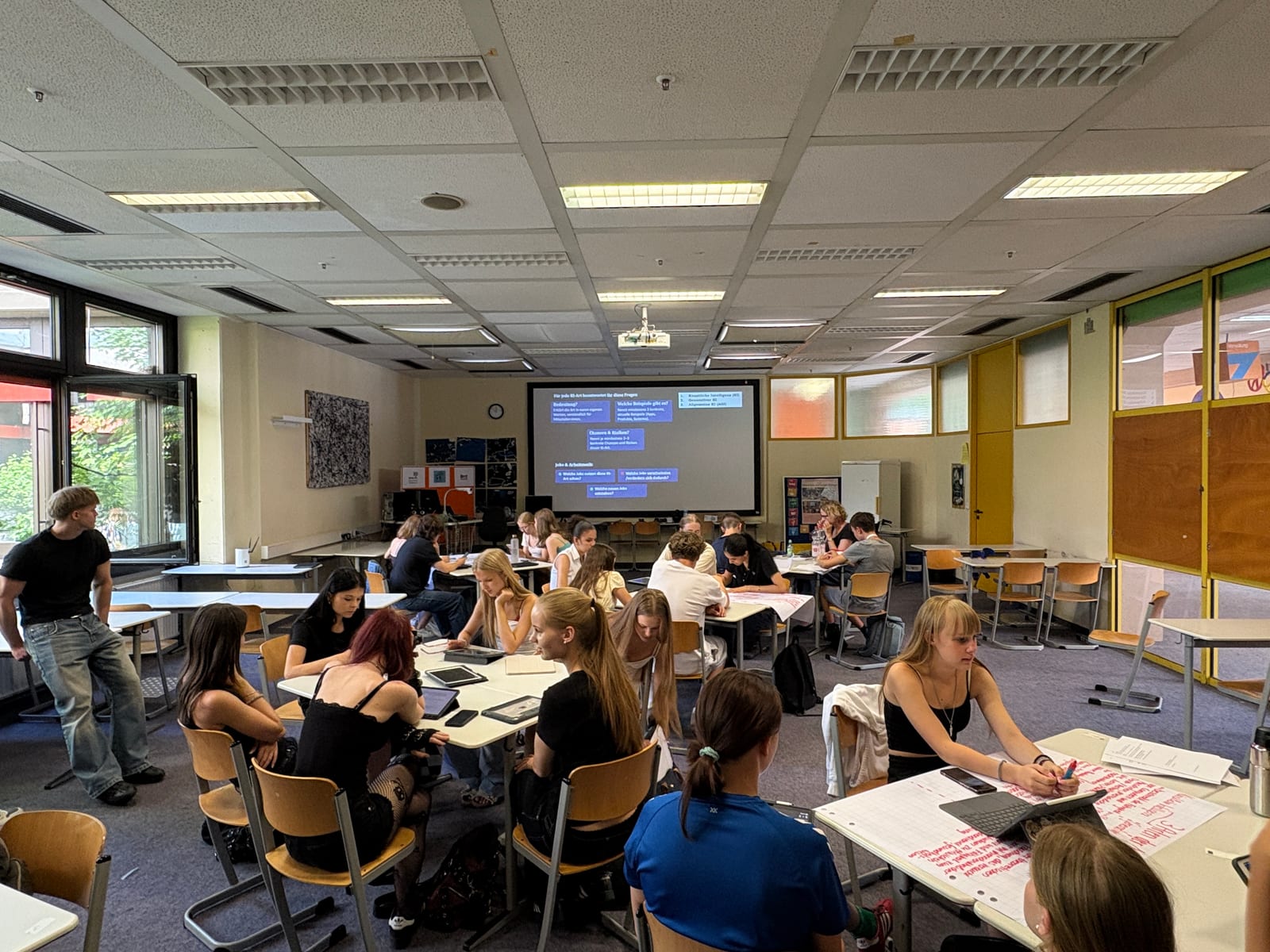 Schulklasse arbeitet im Klassenzimmer an Aufgaben zu KI, Jobs und Arbeitswelt
